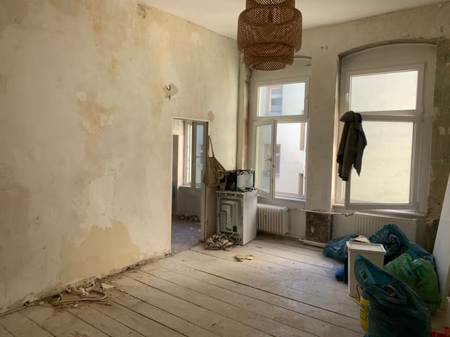 Room stripped back to bare floorboards and walls before renovation
