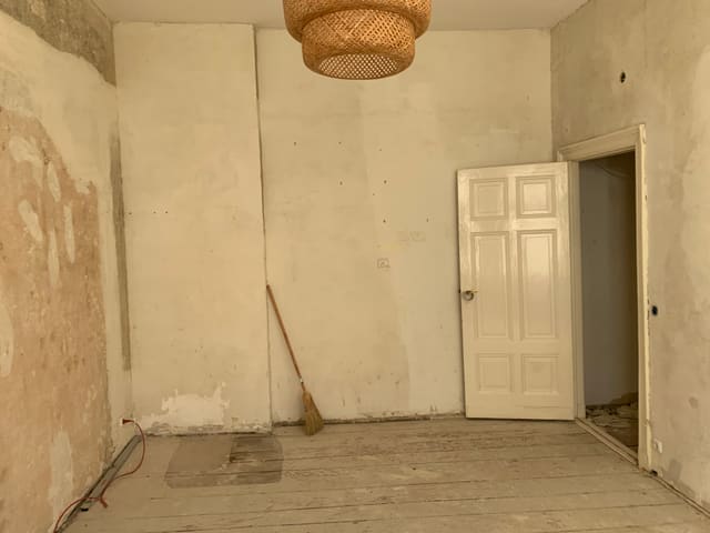 Empty room stripped back to bare floorboards before renovation