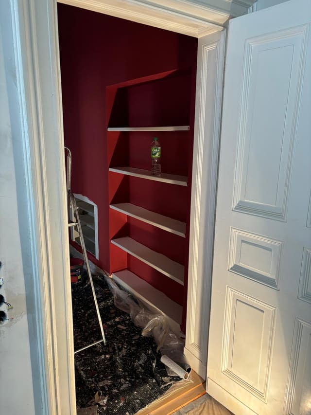 Built-in alcove shelving painted deep red as a feature
