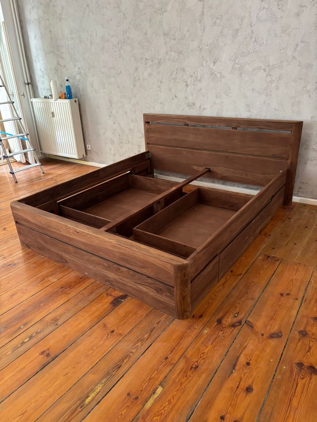 Wood bed frame being assembled in a newly renovated room