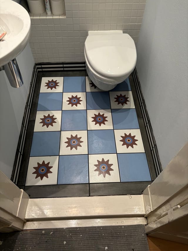 Finished bathroom with blue and white star-pattern tiled floor
