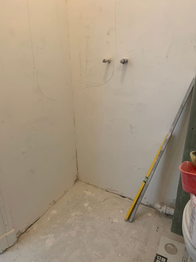 Waterproof membrane applied in a shower corner ahead of tiling