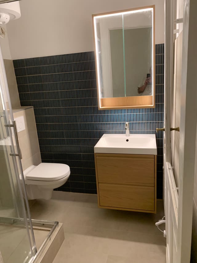 Overhead view of a finished bathroom with dark tiling, vanity and toilet