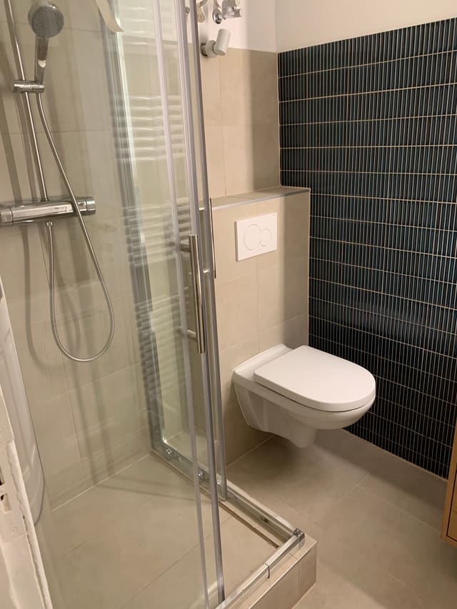 Finished bathroom with toilet and glass shower screen