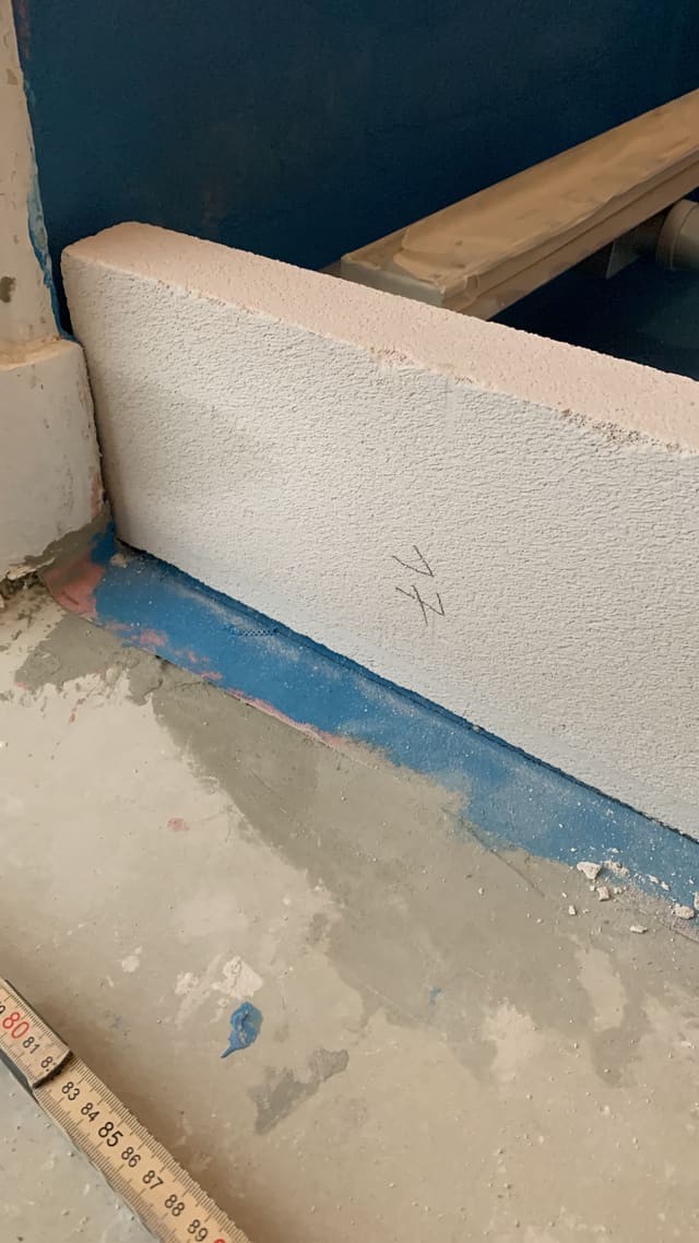 Insulation board fitted against a tanked bathroom wall ahead of tiling