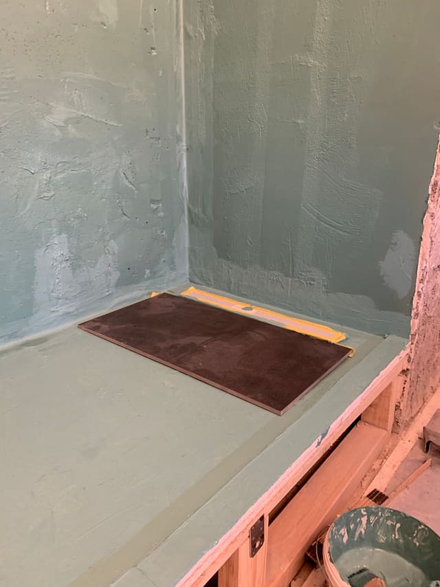 Waterproof membrane applied to a shower tray ahead of tiling