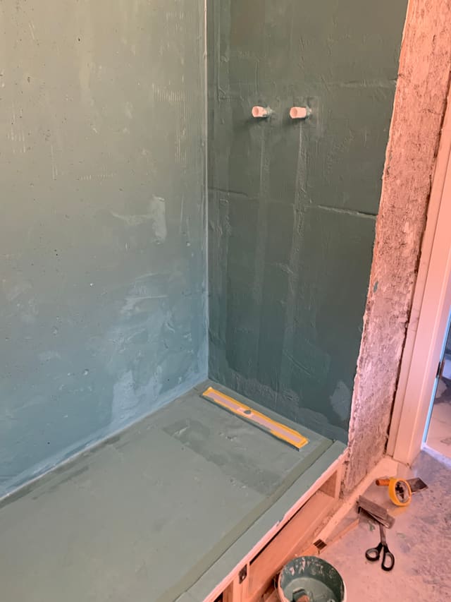 Tanked shower corner with copper pipework exposed