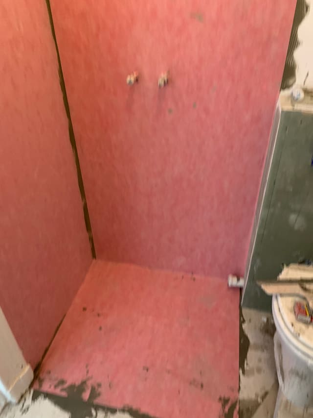 Waterproof membrane applied to shower walls ahead of tiling