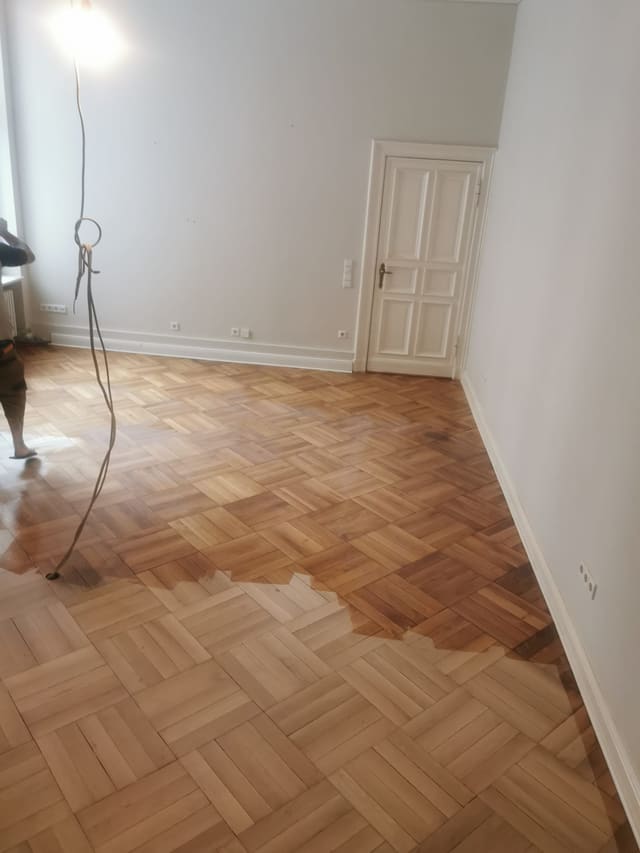 Corridor with restored parquet flooring lit by a window