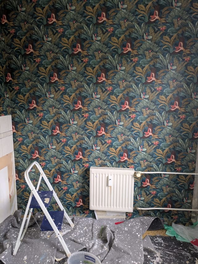 Room mid-decoration with botanical wallpaper going up