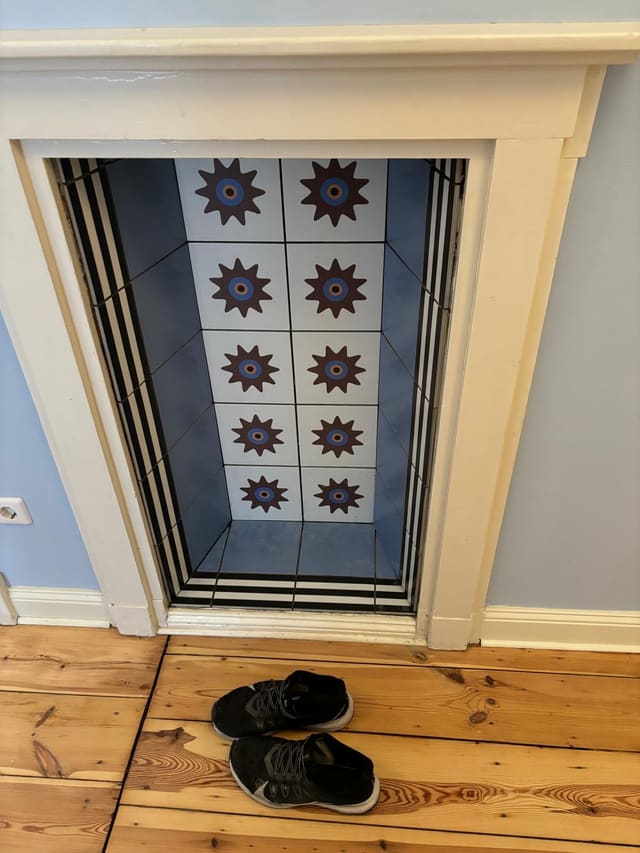 Finished fireplace surround with blue and white star-pattern tiles